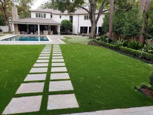 private estate with putting green and pavers surrounded by artificial grass lawn
