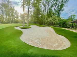 custom sand bunker in backyard golf green installation