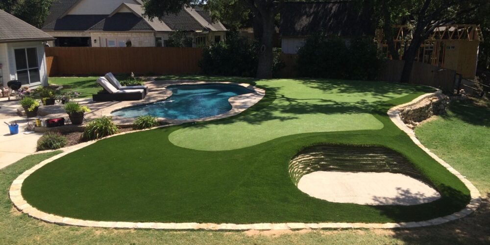 backyard transformation with putting green and stacked sod bunker