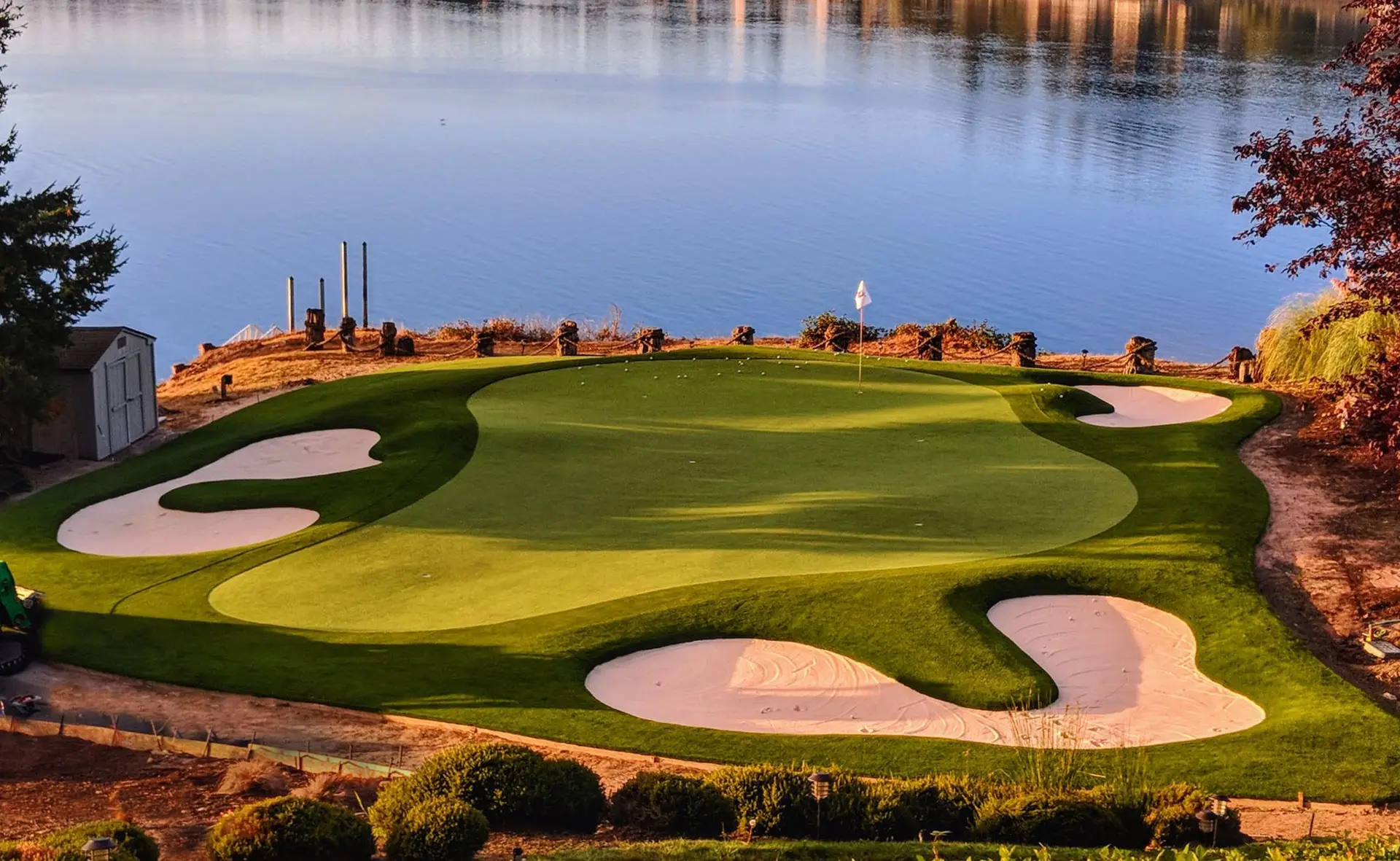 Backyard putting green with artificial turf, contoured elevations, lighting, and sand bunker at a private Gig Harbor residence by Celebrity Greens®