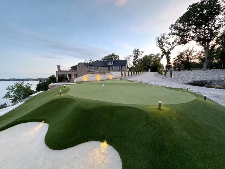 Backyard putting green with artificial turf, contoured elevations, lighting, and sand bunker at a private Gig Harbor residence by Celebrity Greens®